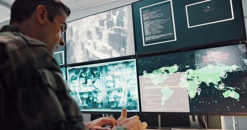gis analyst at computer with monitors displaying geographic information